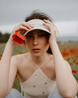 Portrait of young woman drinking water against sky