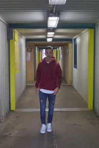Full length portrait of man standing in corridor