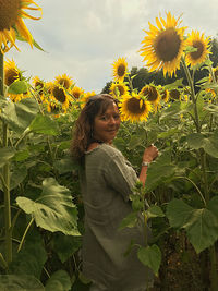 Woman standing in sunflower field