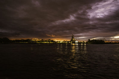 View of river against cloudy sky at dusk