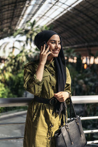 Portrait of young woman standing in city