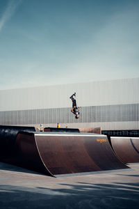 Man skateboarding on skateboard against sky