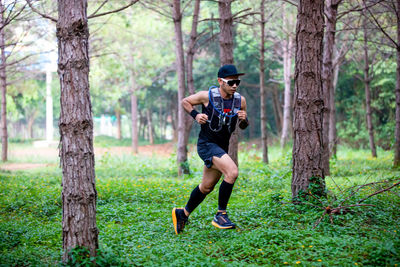 Full length of man running on road in forest