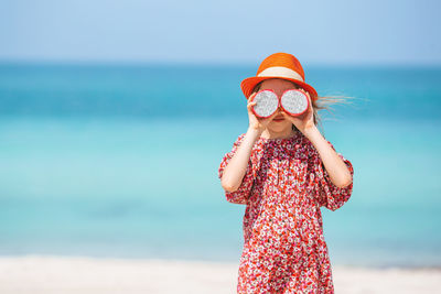 Girls holding food while standing at beach