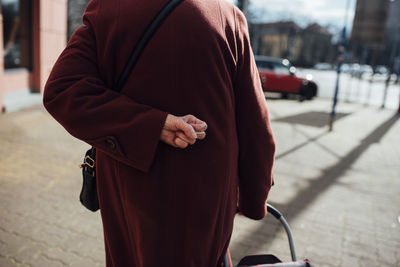 Midsection of man standing on footpath