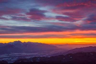 Scenic view of snowcapped mountains against dramatic sky