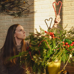 Woman decorating christmas tree at home