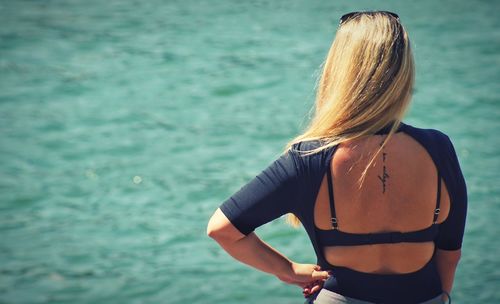 Rear view of woman standing in sea