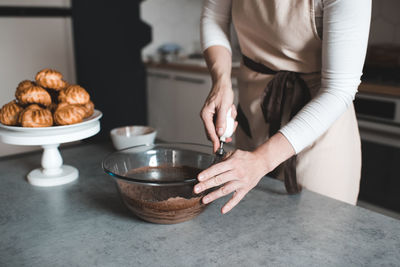 Woman making batter for chocolate cake on kithen table close up. motherhood. breakfast time.