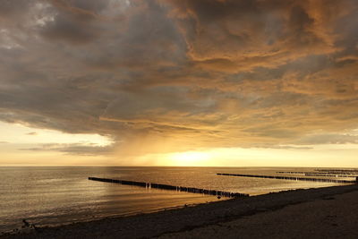 Scenic view of beach against sky during sunset