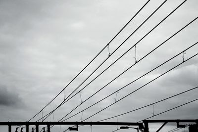 Low angle view of suspension bridge against sky