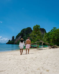 People at beach against sky