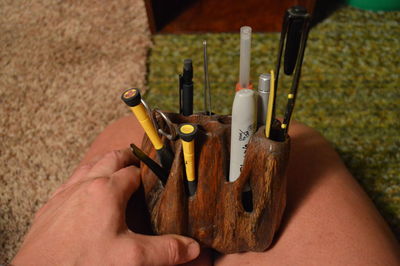 Cropped image of hand holding pencil holder