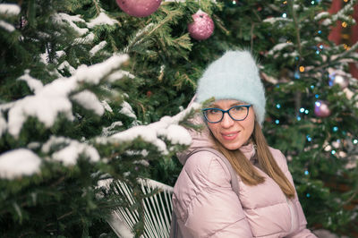 Portrait of young woman standing on tree