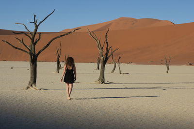 Woman standing on sand dune in desert