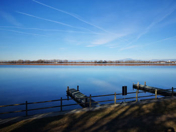 Pier over lake against blue sky