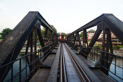 Footbridge over railroad tracks against clear sky