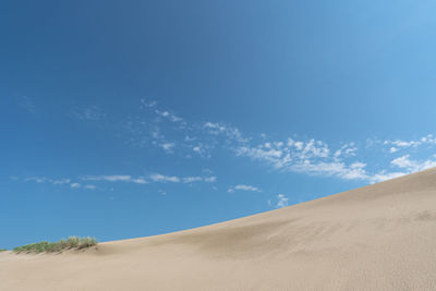 Scenic view of desert against blue sky