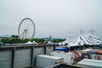 Ferris wheel by river against sky