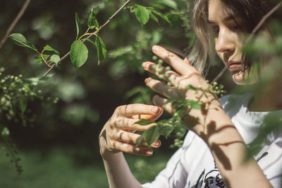 Portrait of woman holding girl eating plant