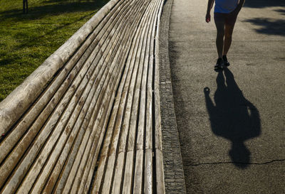 Low section of woman walking on footpath