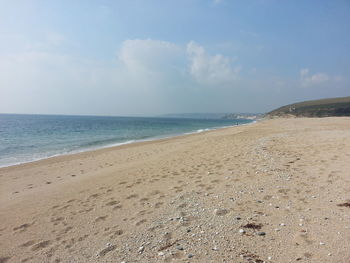 Scenic view of beach against cloudy sky