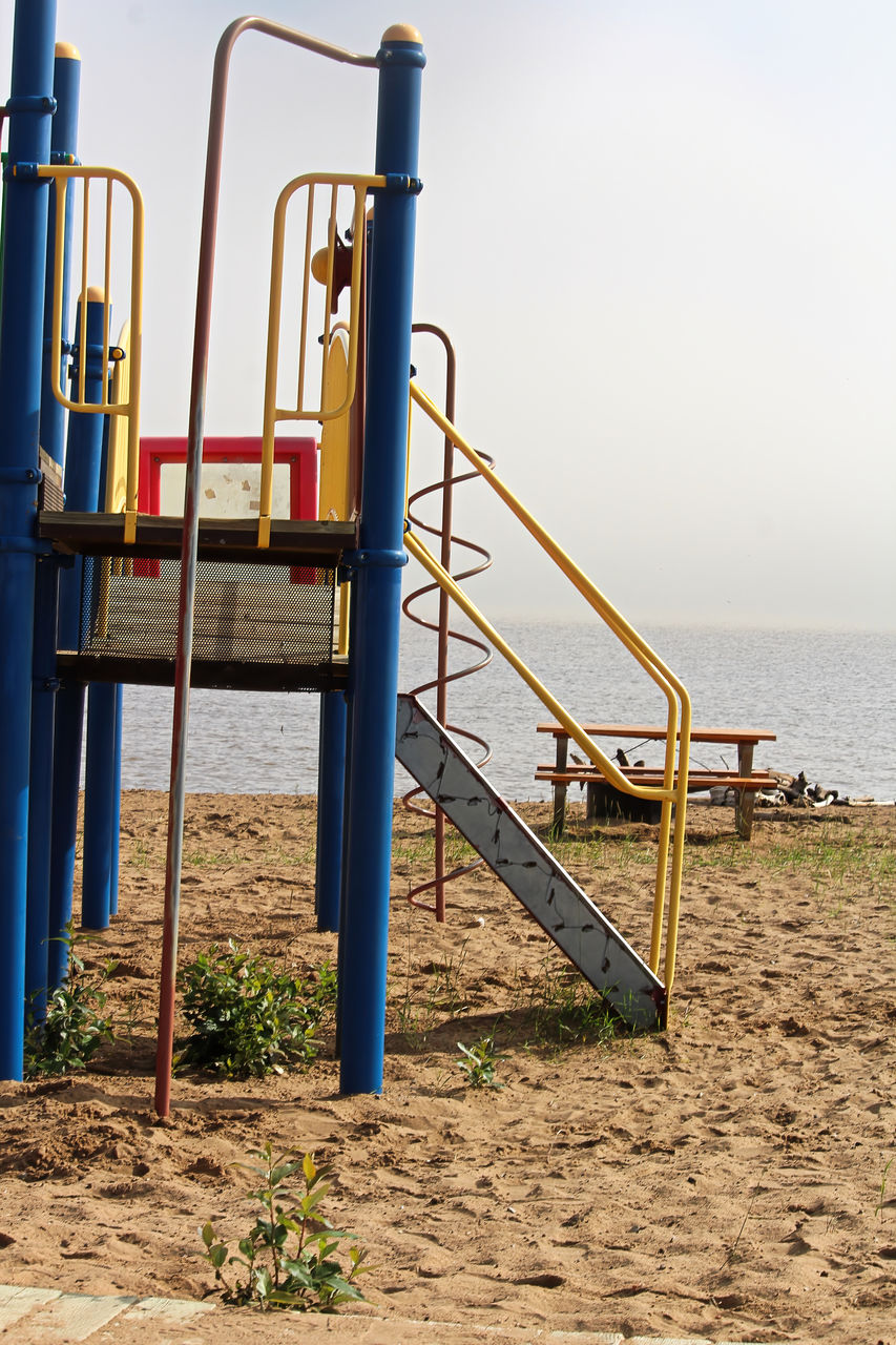 EMPTY PLAYGROUND AT BEACH AGAINST SKY