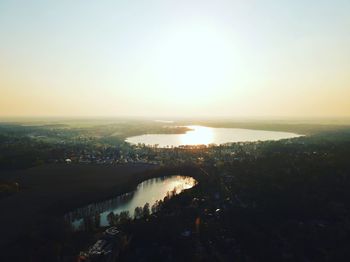 Scenic view of river against clear sky at sunset