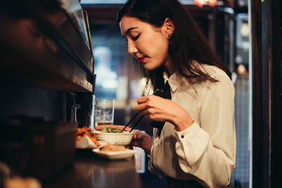 Young woman preparing food in restaurant