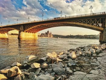 Arch bridge over river against sky