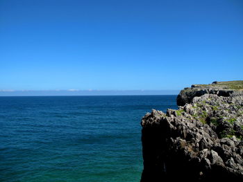 Scenic view of sea against clear blue sky