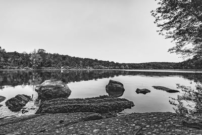 Reflection of rocks in lake against sky