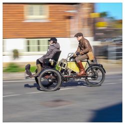 Side view of people riding motorcycle on road