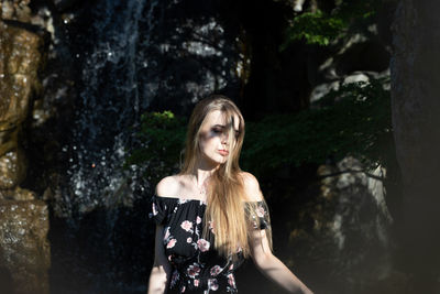 Beautiful woman standing by plants outdoors