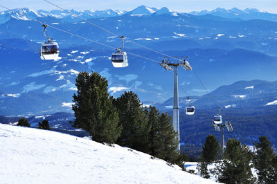 Overhead cable car over snowcapped mountains against sky