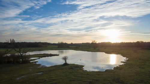 Scenic view of lake against sky at sunset