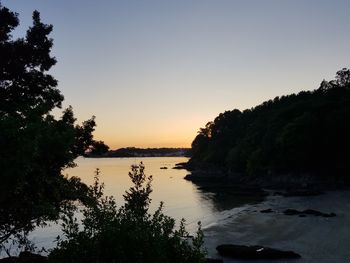 Scenic view of lake against clear sky during sunset