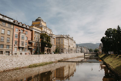 Canal amidst buildings against sky