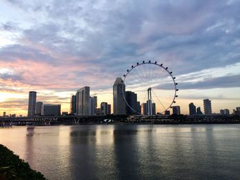 View of ferris wheel in city at sunset