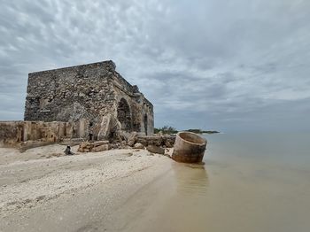 Built structure on beach against sky