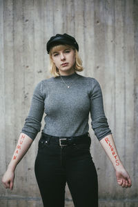 Portrait of female protestor showing equal rights written on hand against wall