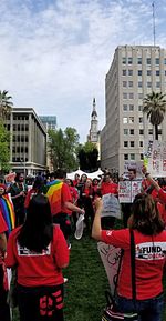 Rear view of people on street against buildings in city