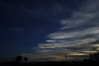 Silhouette of trees against cloudy sky