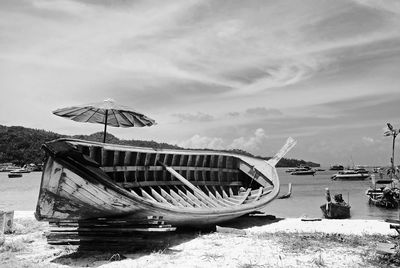 Ship moored on beach against sky