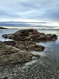Rocks on beach against sky