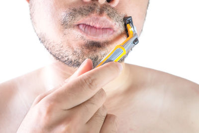 Close-up of man holding hands over white background