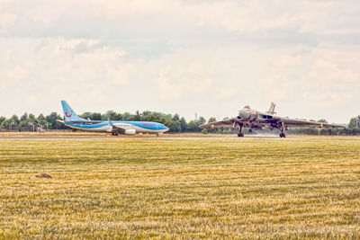 Airplane on field against sky