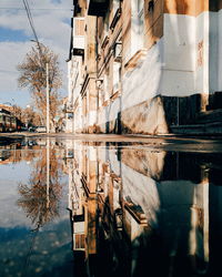 Reflection of building in puddle on lake