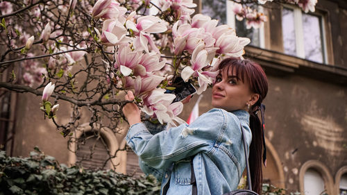 Portrait of woman with pink flowers on tree