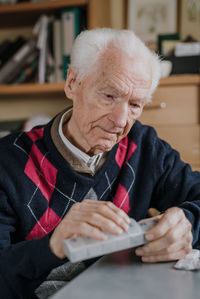 Midsection of man holding hands while sitting on table